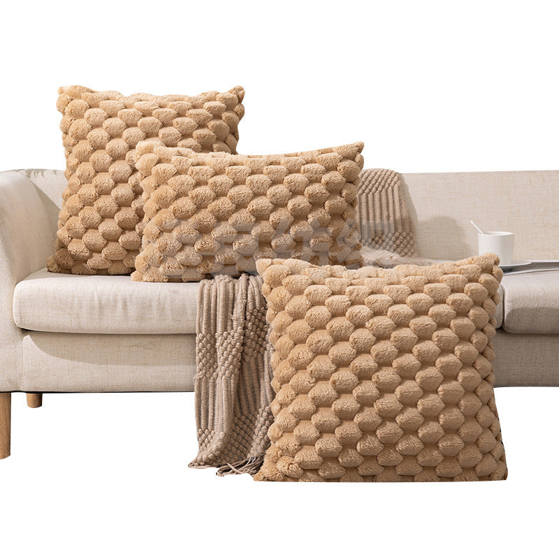 Woven fleece solid color waist pillow cover on a soft grey sofa in a cozy room

