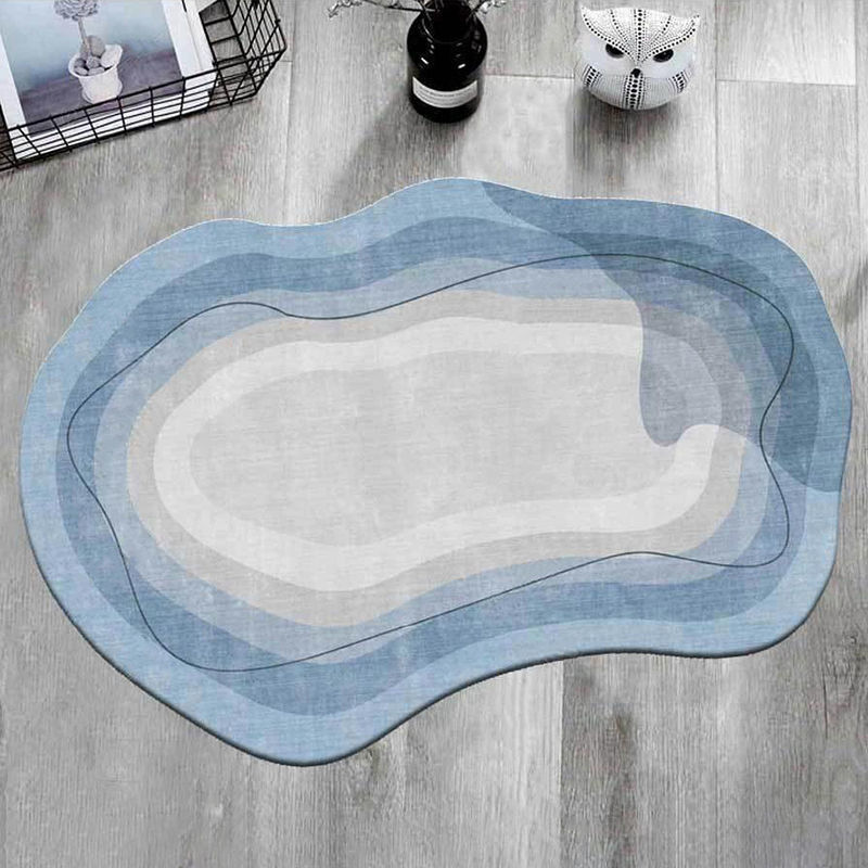 Irregular shaped carpet placed under a coffee table in a modern living room with artistic décor


