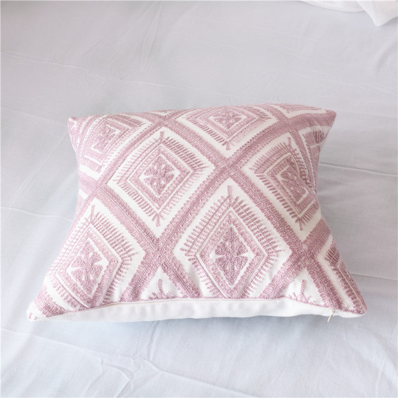 Geometric embroidered cotton pillowcase on a modern sofa with decorative cushions

