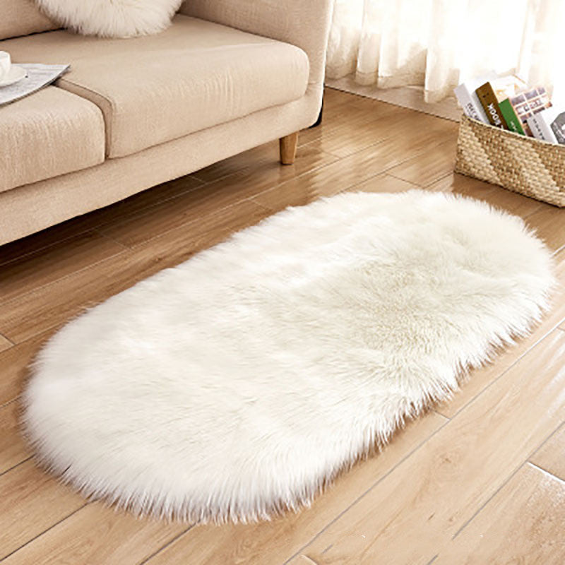 Oval wool-like carpet placed in a bedroom near the bed with cozy home décor

