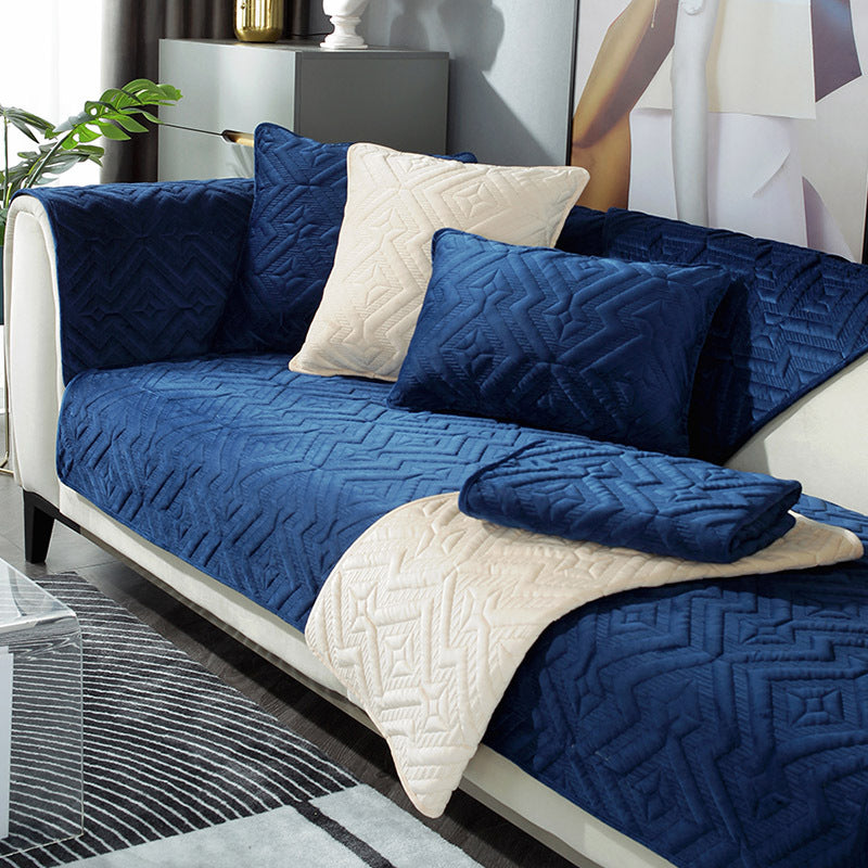 Black plush winter sofa cushion on a leather sofa with thick quilted texture

