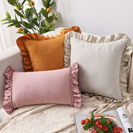 Small suede cushion pillowcase placed on a sofa beside a neutral-toned bed setup

