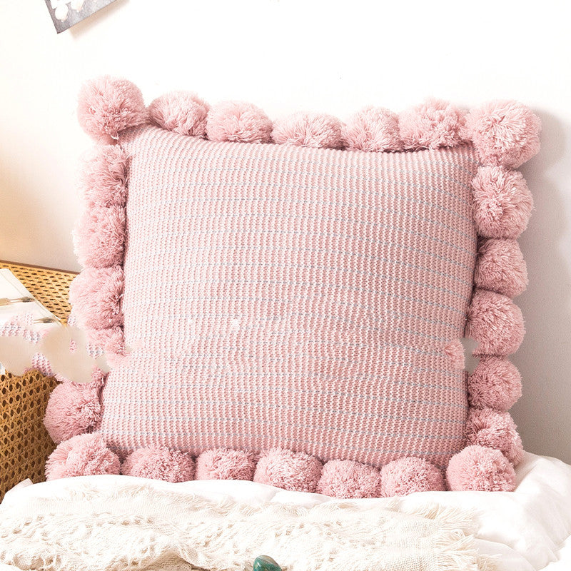 Knitted waist pillowcase on a neutral-toned bed with cozy decorative pillows

