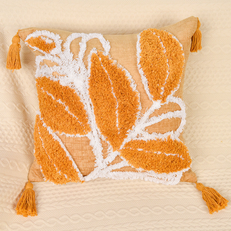 Tufted leaf design throw pillow on a neutral-toned sofa in a cozy living room

