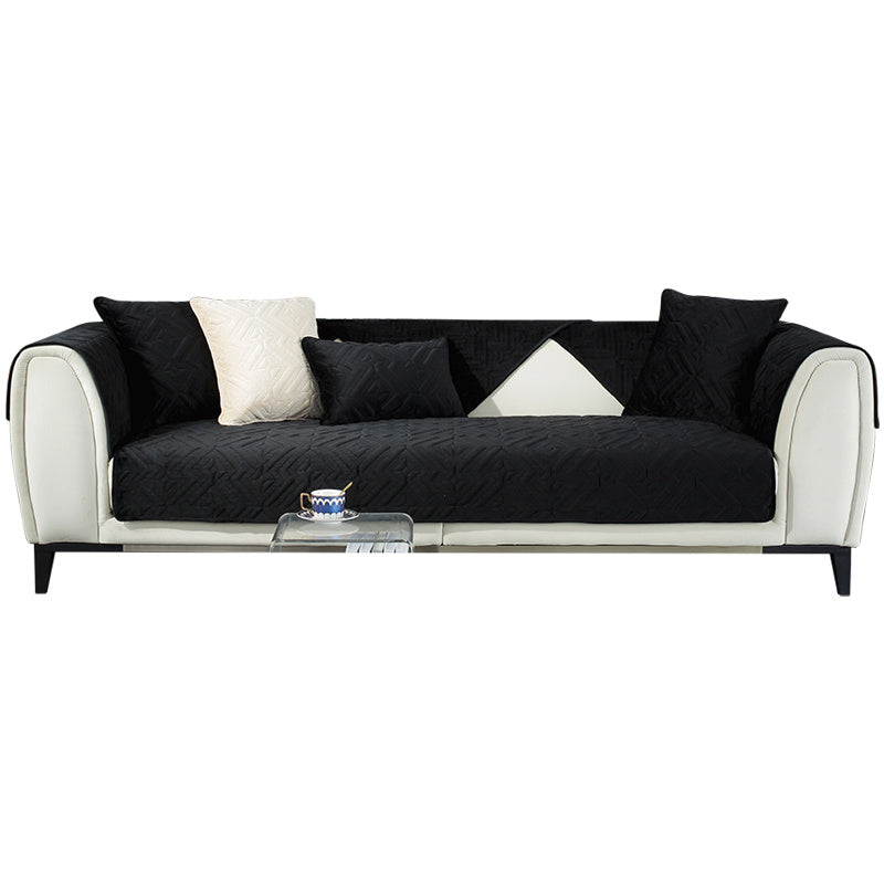 Black plush winter sofa cushion on a leather sofa with thick quilted texture

