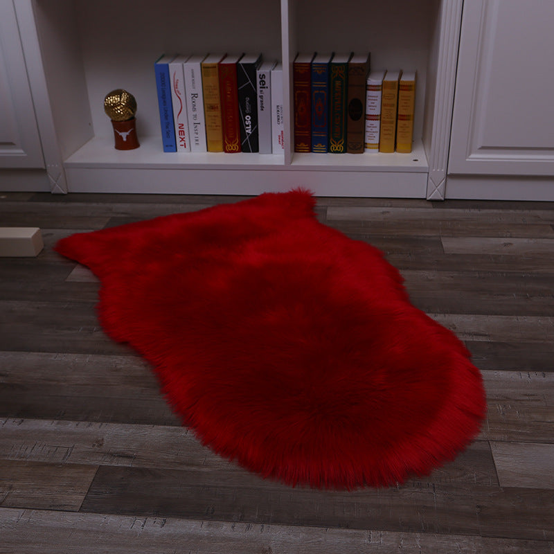 Plush carpet floor mat placed in a bedroom near the bed on a wooden floor

