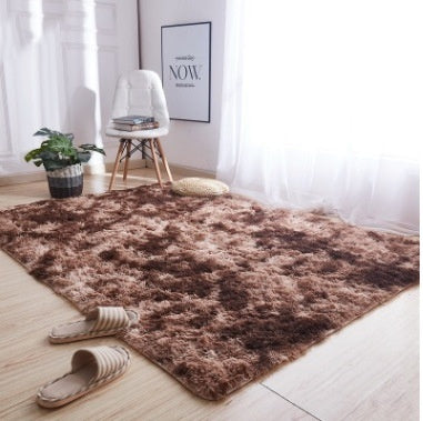 Tie-dye gradient rug with long wool texture beside a bed and end table in a modern bedroom

