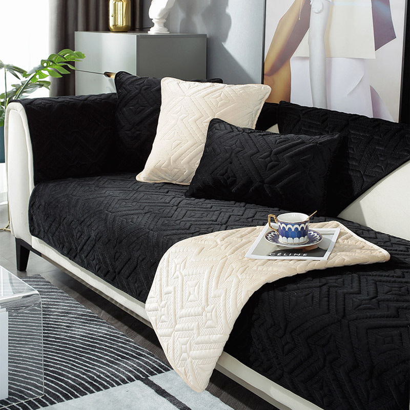 Black plush winter sofa cushion on a leather sofa with thick quilted texture

