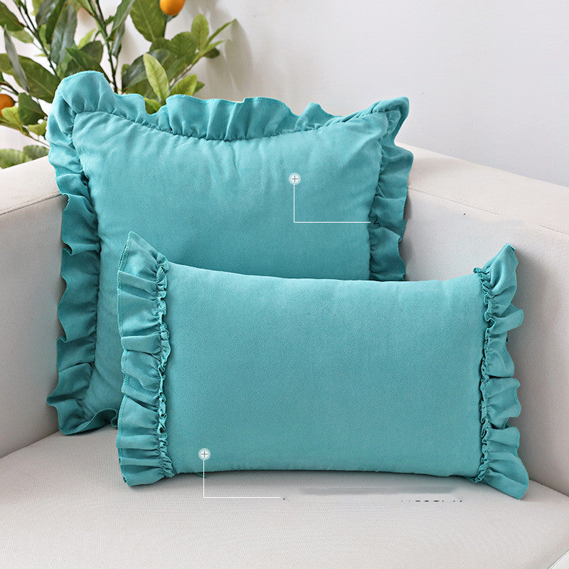 Small suede cushion pillowcase placed on a sofa beside a neutral-toned bed setup

