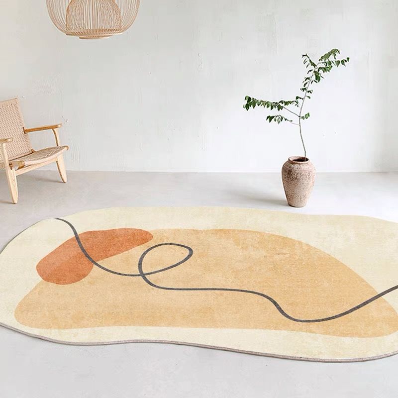 Irregular shaped carpet placed under a coffee table in a modern living room with artistic décor

