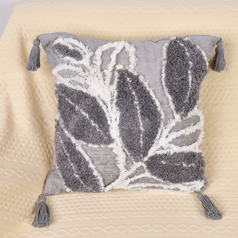 Tufted leaf design throw pillow on a neutral-toned sofa in a cozy living room


