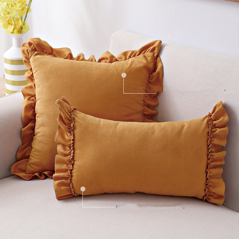 Small suede cushion pillowcase placed on a sofa beside a neutral-toned bed setup

